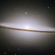 A brilliant white core is encircled by thick dust lanes in this spiral galaxy, seen edge-on. The galaxy is 50,000 light-years across and 28 million light years from Earth.